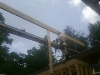 Carpenter setting a ridge beam over a new addition frame — Ice Dam Removal by Roofing Brothers in Poynette