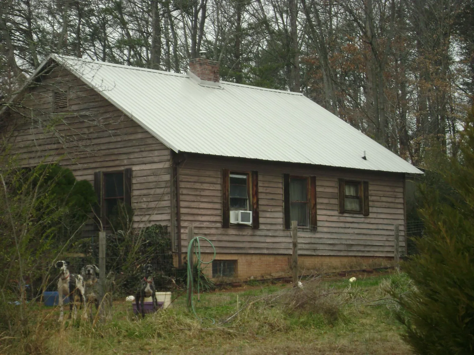 White metal roof on an old wood sided farmhouse, from a Metal Roof Installation job in Poynette